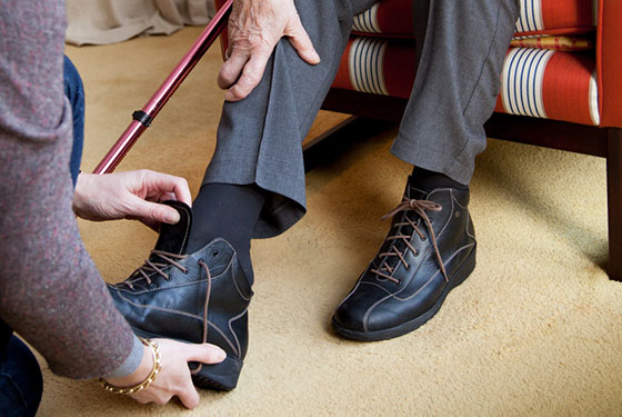 Saar ondersteunt ouderen met schoenen aantrekken